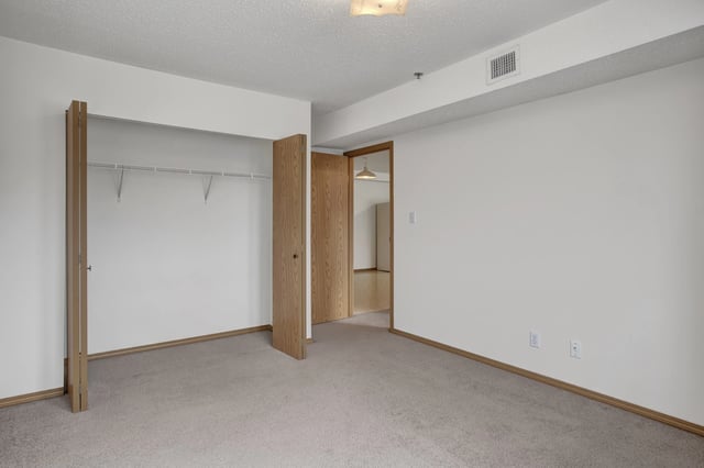 Bedroom with closet and doorway to hallway.