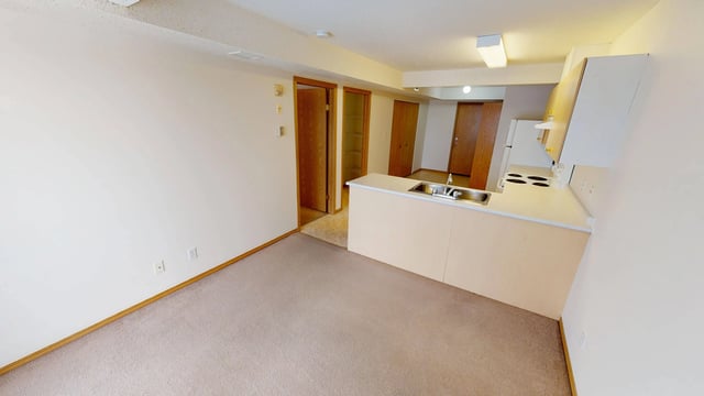Interior view of an apartment showing a kitchen counter and a living area.