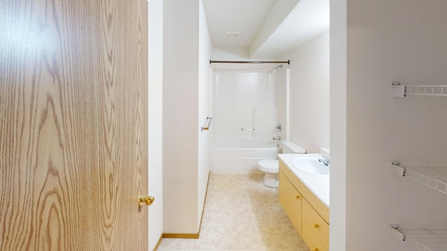 Bathroom with a vanity, toilet, and bathtub/shower combo.