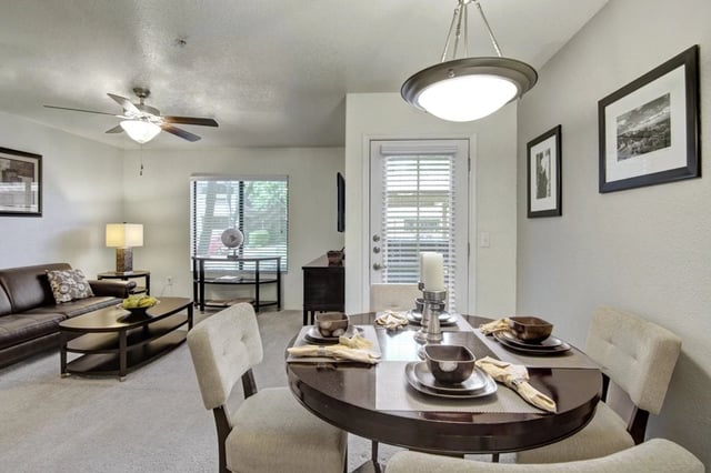 Spacious living and dining area with modern furnishings, including a sofa, coffee table, and dining set.
