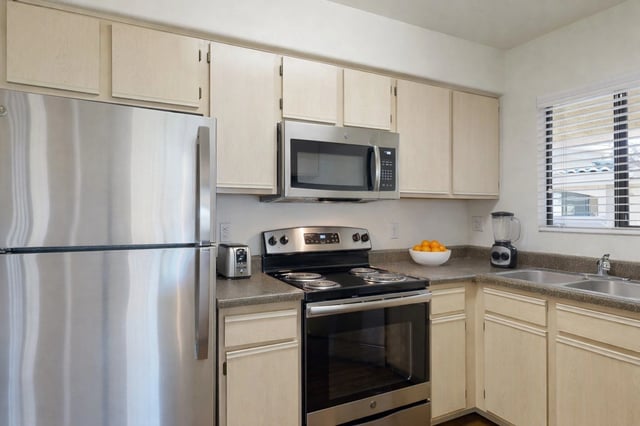 Kitchen with stainless steel appliances, including a refrigerator, microwave, and stove.