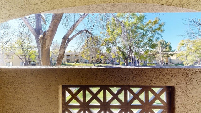 View of apartment buildings and trees from a balcony.