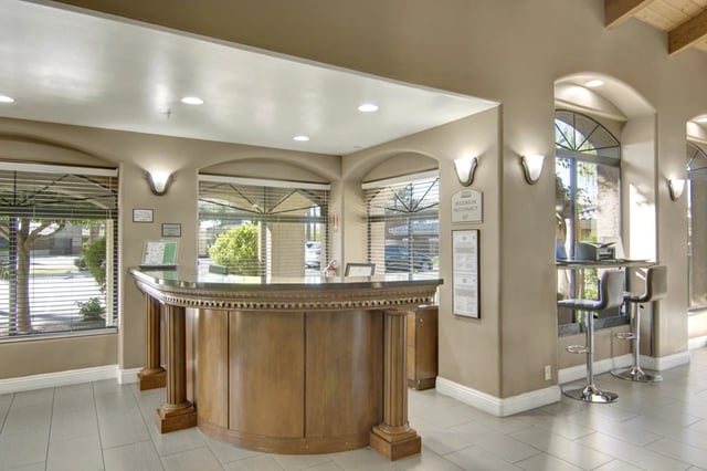 Reception desk and seating area with arched windows and outdoor views.