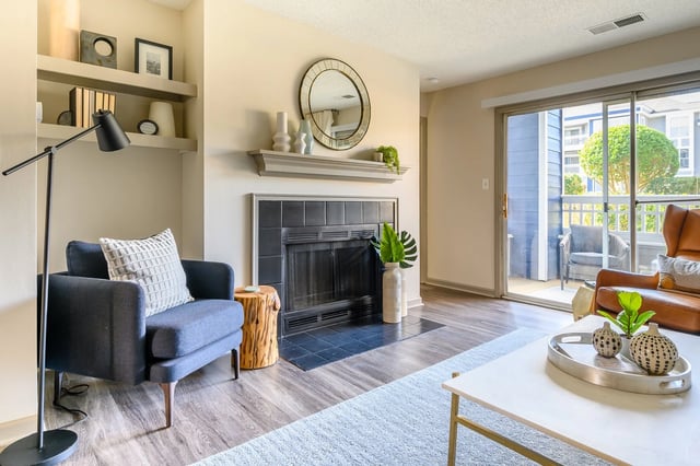 Living room with fireplace, shelving, and balcony access.