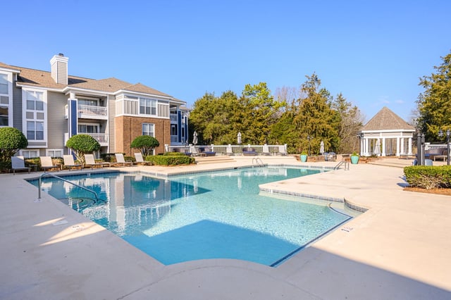 Resort-style pool with lounge chairs and cabana.