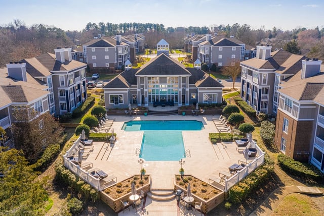 Aerial view of a resort-style swimming pool and surrounding apartment buildings.