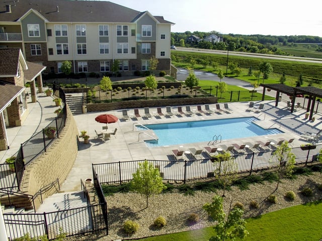 Resort-style swimming pool and lounge area at an apartment complex.
