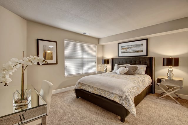 Bedroom with a queen-size bed, nightstands, desk, and decorative elements.