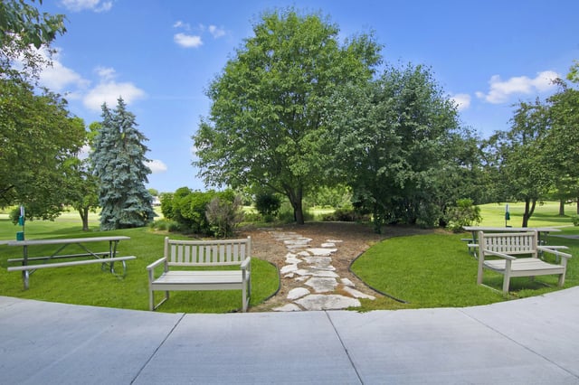 Park-like setting with benches, picnic tables, and a stone pathway.