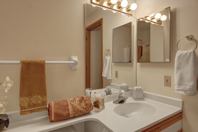 Bathroom vanity with double sinks, large mirror, and towels.