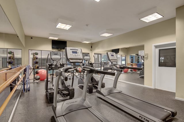 Gym with treadmills, ellipticals, and weights.