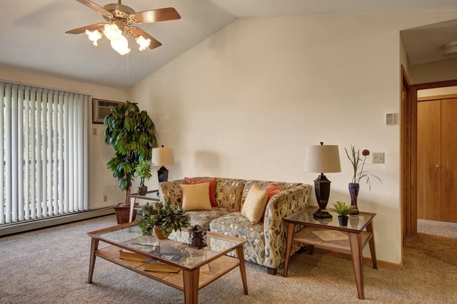 Living room with a sofa, coffee table, and floor-to-ceiling windows.