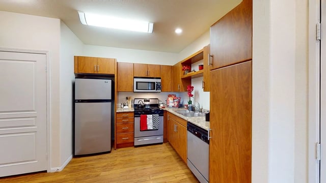 Modern kitchen with wood cabinets, stainless steel appliances, and granite countertops.