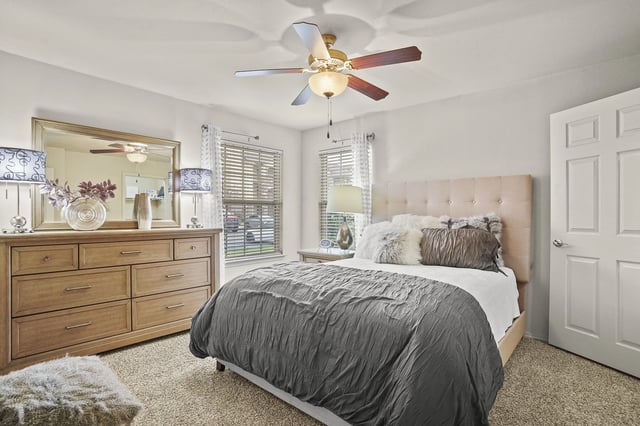A bedroom with a bed, dresser, and mirror.