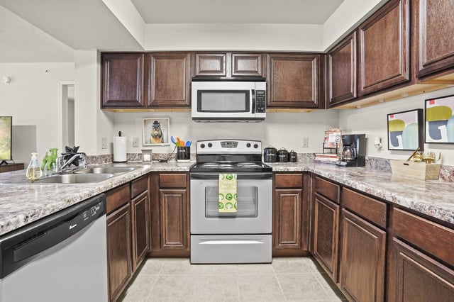 A kitchen with a stove top oven and microwave above it.