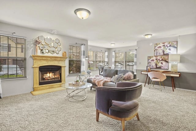 Spacious resident lounge with a gas fireplace, comfortable seating, and large windows.