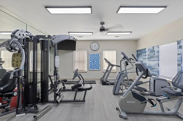 Fitness center in an apartment community with cardio machines and weight equipment.