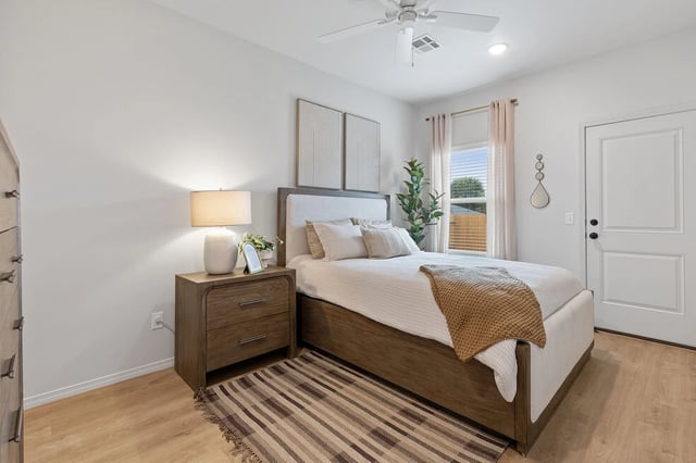 Cozy bedroom with a twin bed, nightstand, and large window.
