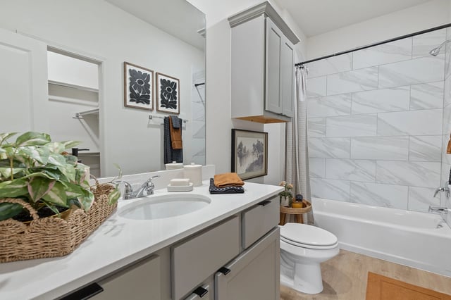 Modern bathroom with vanity, toilet, and bathtub.