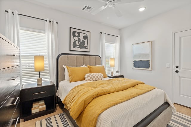 Cozy bedroom with a queen-size bed, yellow bedding, and nightstands.