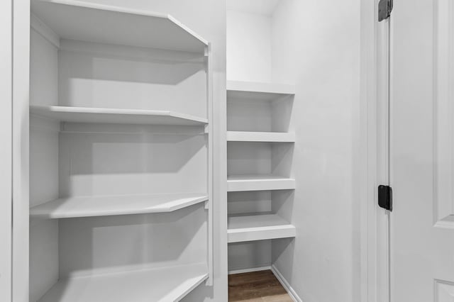 Empty white walk-in closet with shelves.