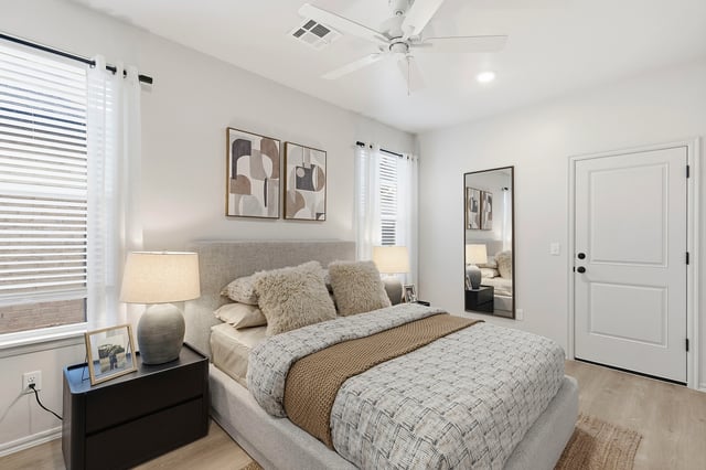 Cozy bedroom featuring a king-size bed, bedside tables, and a full-length mirror.