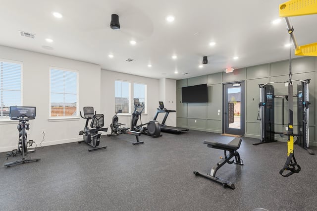 Gym with treadmills, ellipticals, stationary bikes, and weight machines.