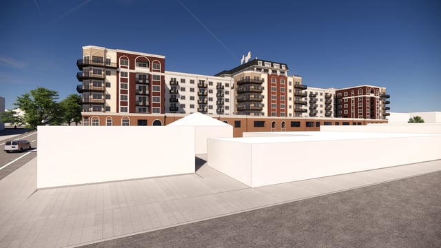 Exterior view of a modern apartment building with balconies and a blue sky.