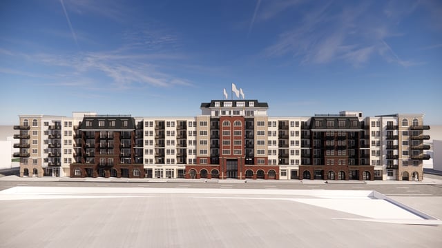 Exterior view of a modern apartment building with balconies and a central brick section.