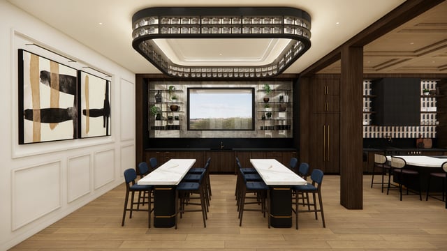 Modern communal lounge with large tables, bar seating, and abstract art.