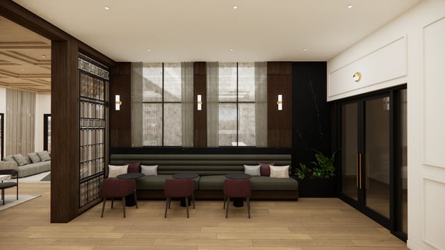 Lobby seating area with plush green sofa, accent chairs, and decorative wall panels.