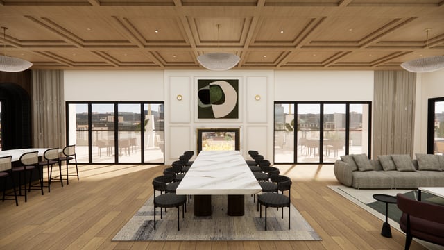 Modern community lounge with a long marble dining table, chairs, fireplace, and a sectional sofa.