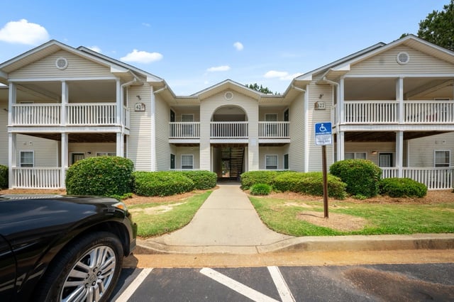 Exterior of apartment building with balconies and walkway.