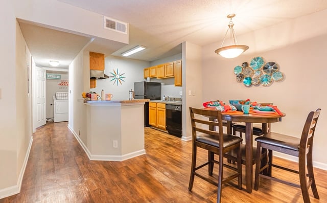 Dining area and kitchen with a table set for four, laundry area visible.