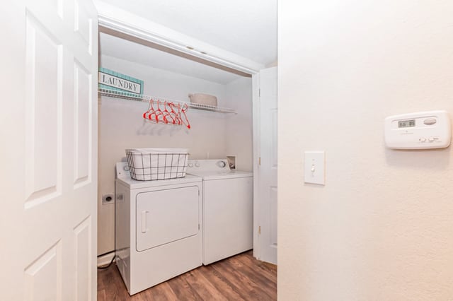 In-unit washer and dryer with a laundry basket on top, and a sign that says laundry. View 1-bedroom apartments for rent in East Point GA—schedule a tour or call to learn more.