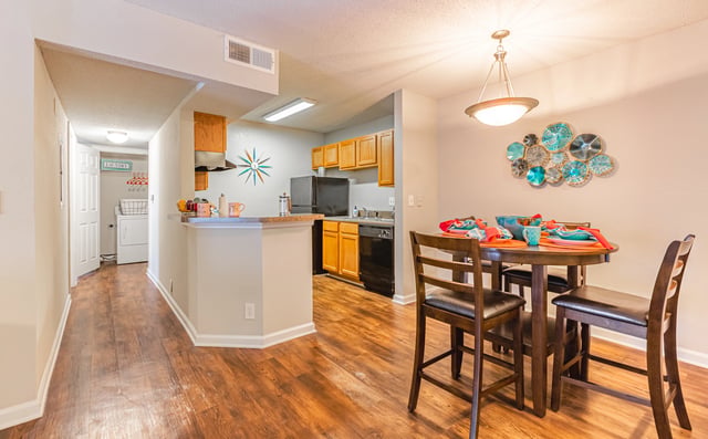 Dining area adjacent to kitchen with washer/dryer visible in hallway. Discover Rentals in East Point GA—book a tour today or contact us for more information.