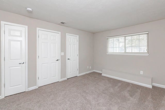 Bedroom with three doors and a window.