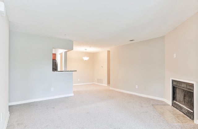 Spacious living room with fireplace and open kitchen view.