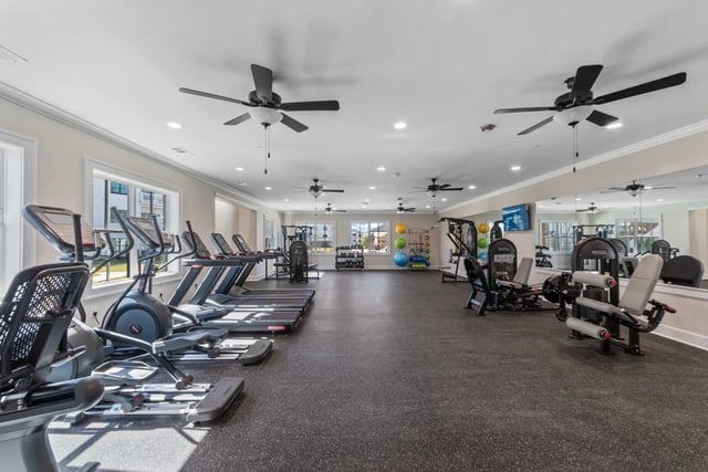Fitness center with treadmills, elliptical machines, and weight machines.