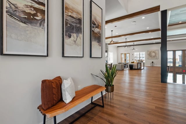 Modern lobby area with wooden bench, artwork, and open seating space.