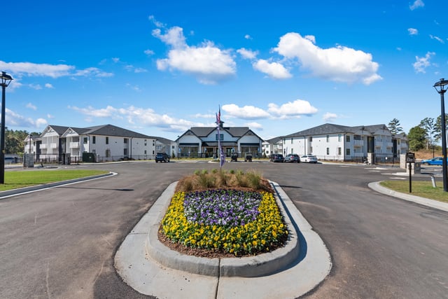 Exterior view of apartment buildings and clubhouse with landscaping at The Blakely, offering apartments for rent in Pendergrass, GA.