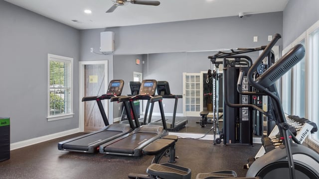 Apartment fitness center with treadmills and elliptical machine.