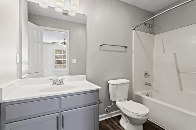 Modern bathroom with vanity, toilet, and bathtub.