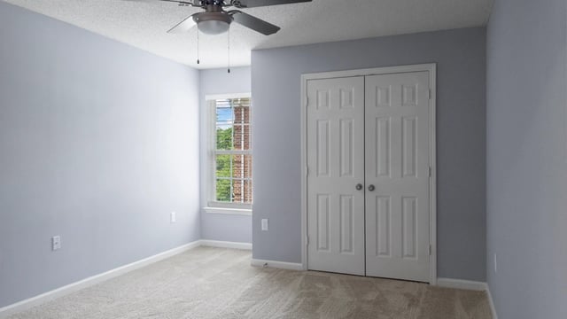 Bedroom with a closet and a window with a ceiling fan