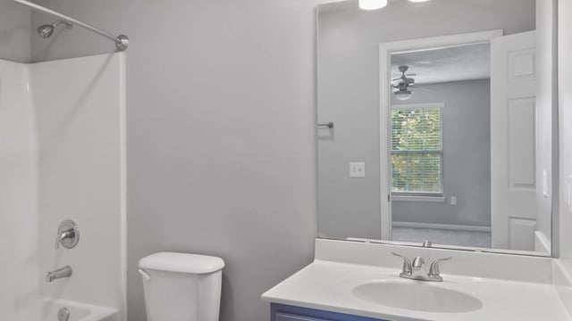 Modern bathroom with a toilet, sink, and shower. A mirror reflects a bedroom.
