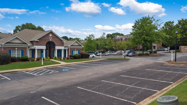 Exterior view of the apartment complex's main building and parking lot.