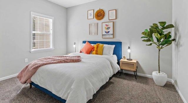 Bedroom with a queen-size bed, plush blankets, and modern decor.