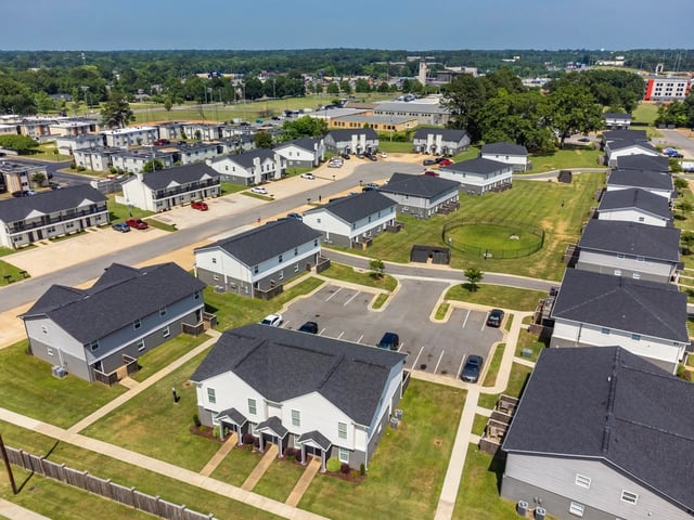 Aerial view of a multifamily property with multiple buildings and manicured lawns.