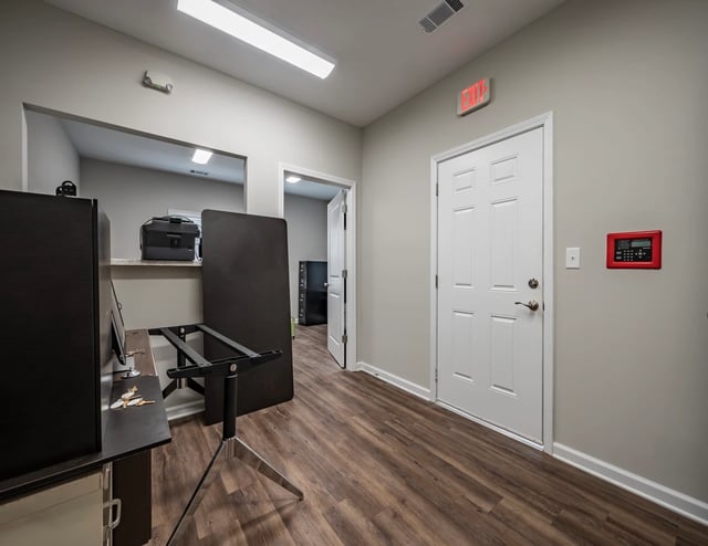 Interior hallway with a white door and an exit sign.