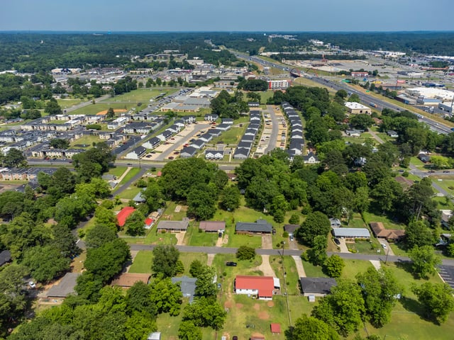 Aerial view of a suburban neighborhood with apartment buildings and single-family homes.